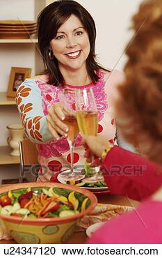 Stock Photography - mature woman and 
her friend toasting 
with champagne 
flutes. fotosearch 
- search stock 
photos, pictures, 
images, and photo 
clipart