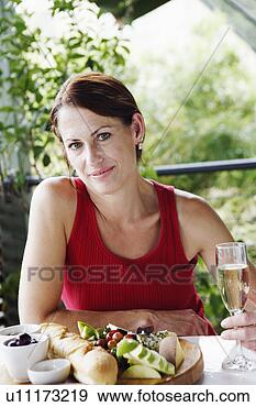 Stock Photograph - portrait of a 
mature woman sitting 
at a table and 
smiling. fotosearch 
- search stock 
photos, pictures, 
images, and photo 
clipart