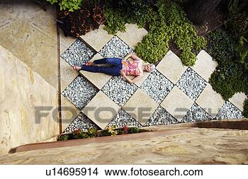 Stock Photo - high angle view 
of a senior woman 
lying in a garden. 
fotosearch - search 
stock photos, 
pictures, images, 
and photo clipart