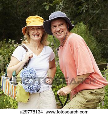 Stock Photo - portrait of a 
mature couple 
standing together 
in a garden and 
smiling. fotosearch 
- search stock 
photos, pictures, 
images, and photo 
clipart