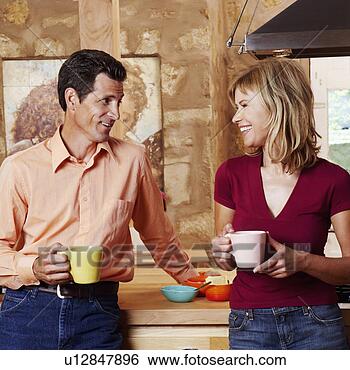 Stock Photo - mature couple 
holding cups and 
smiling. fotosearch 
- search stock 
photos, pictures, 
images, and photo 
clipart