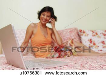 Arquivo de Fotografia - close-up,   laptop, 
  maduro,   mulher, 
  falando,   móvel. 
fotosearch - busca 
de fotos, imagens 
e clipart