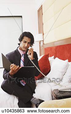 Stock Photo - businessman talking 
on the telephone 
and reading a 
file. fotosearch 
- search stock 
photos, pictures, 
images, and photo 
clipart