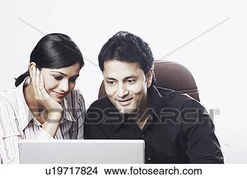Stock Photo - close-up of a 
businessman and 
a businesswoman 
working on a laptop. 
fotosearch - search 
stock photos, 
pictures, images, 
and photo clipart