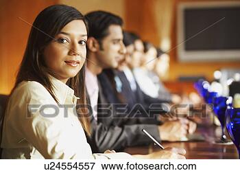 Picture - portrait of a 
businesswoman 
sitting with her 
colleagues in 
a. fotosearch 
- search stock 
photos, pictures, 
images, and photo 
clipart