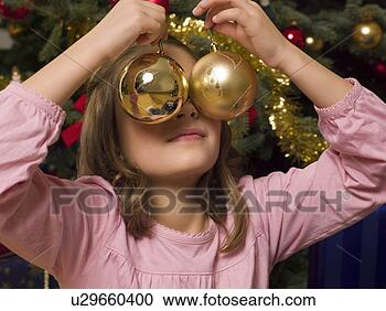 Stock Photography - girl covering 
eyes with christmas 
decorations. fotosearch 
- search stock 
photos, pictures, 
images, and photo 
clipart
