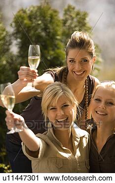 Stock Photography - portrait of two 
young women holding 
champagne flutes 
with a young. 
fotosearch - search 
stock photos, 
pictures, images, 
and photo clipart