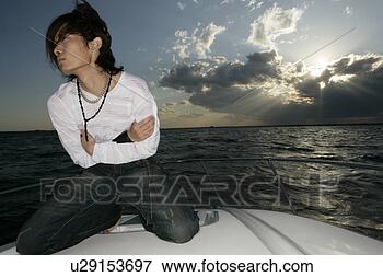 Picture - view of man kneeling 
on a yacht. fotosearch 
- search stock 
photos, pictures, 
images, and photo 
clipart