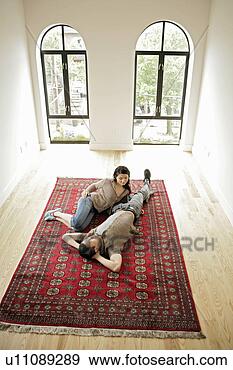 Stock Photograph - young couple resting 
on carpet, high 
angle view. fotosearch 
- search stock 
photos, pictures, 
images, and photo 
clipart