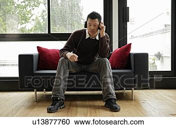 Stock Photography - a young man listening 
music with head 
phones. fotosearch 
- search stock 
photos, pictures, 
images, and photo 
clipart