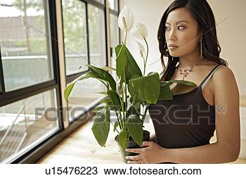 Stock Photo - young woman holding 
potted plant, 
portrait. fotosearch 
- search stock 
photos, pictures, 
images, and photo 
clipart