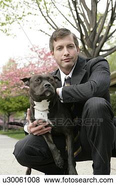 Stock Photo - business man holding 
a dog. fotosearch 
- search stock 
photos, pictures, 
images, and photo 
clipart