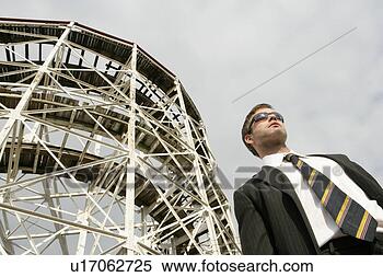 Stock Image - business man standing 
near a large metal 
structure. fotosearch 
- search stock 
photos, pictures, 
images, and photo 
clipart