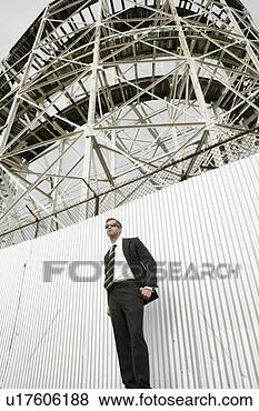 Stock Photo - business man staning 
in front of large 
structure. fotosearch 
- search stock 
photos, pictures, 
images, and photo 
clipart