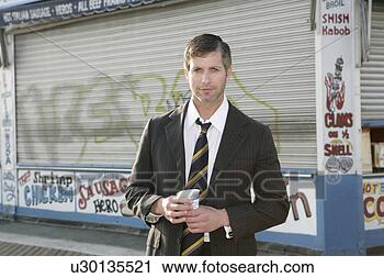 Stock Photography - man in a suit 
standing in front 
of a closed fast 
food place. fotosearch 
- search stock 
photos, pictures, 
images, and photo 
clipart