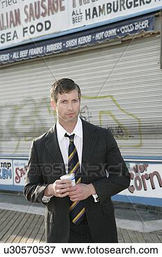 Picture - man in a suit 
standing in front 
of a closed fast 
food place. fotosearch 
- search stock 
photos, pictures, 
images, and photo 
clipart