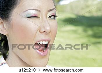 Picture - close-up of a 
young woman winking. 
fotosearch - search 
stock photos, 
pictures, images, 
and photo clipart