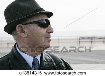 Stock Image - mature man outdoors 
wearing a hat 
and shades. fotosearch 
- search stock 
photos, pictures, 
images, and photo 
clipart