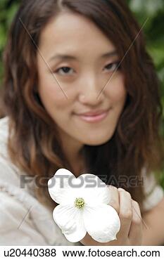 Stock Photo - young woman holding 
flower, close-up. 
fotosearch - search 
stock photos, 
pictures, images, 
and photo clipart