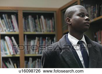 Stock Photo - boy (11-13) in 
library, looking 
away. fotosearch 
- search stock 
photos, pictures, 
images, and photo 
clipart