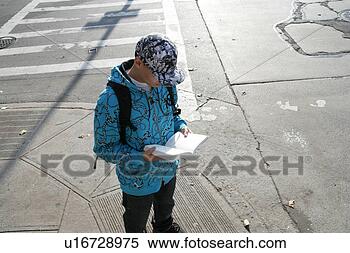 Stock Image - teenage boy (15-17) 
reading book on 
road. fotosearch 
- search stock 
photos, pictures, 
images, and photo 
clipart