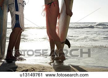 Stock Photography - view of a couple 
standing with 
surfboards. fotosearch 
- search stock 
photos, pictures, 
images, and photo 
clipart