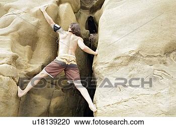 Stock Photography - view of a young 
man rock climbing. 
fotosearch - search 
stock photos, 
pictures, images, 
and photo clipart
