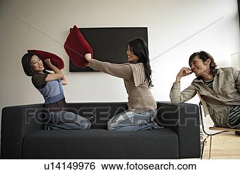 Stock Photo - two women fighting 
with pillows while 
man observing, 
side view. fotosearch 
- search stock 
photos, pictures, 
images, and photo 
clipart