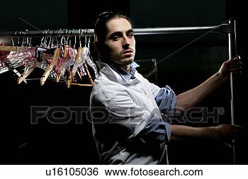 Stock Photo - young man holding 
a clothing rack. 
fotosearch - search 
stock photos, 
pictures, images, 
and photo clipart