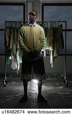 Stock Photo - young man standing 
in front of a 
clothing rack. 
fotosearch - search 
stock photos, 
pictures, images, 
and photo clipart