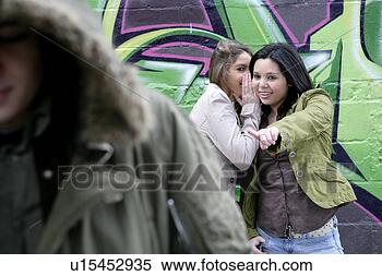 Stock Image - view of two young 
women gossiping. 
fotosearch - search 
stock photos, 
pictures, images, 
and photo clipart