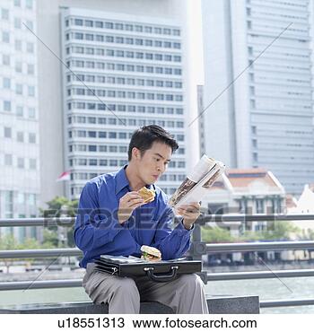 Stock Photo - businessman eating 
a burger and reading 
a magazine. fotosearch 
- search stock 
photos, pictures, 
images, and photo 
clipart