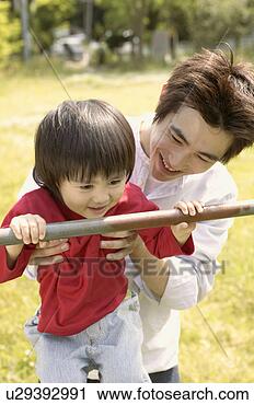 Stock Photography - father lifts up 
his son for holding 
a metallic rod. 
fotosearch - search 
stock photos, 
pictures, images, 
and photo clipart