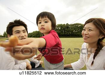 Stock Photo - a small boy offering 
a piece of some 
edible as the 
parents looks 
on. fotosearch 
- search stock 
photos, pictures, 
images, and photo 
clipart