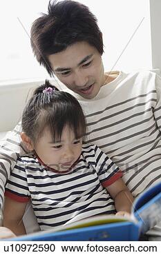 Stock Photography - a young farther 
reading a book 
to his daughter. 
fotosearch - search 
stock photos, 
pictures, images, 
and photo clipart