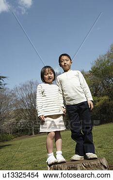 Stock Photo - portrait of children 
standing on wooden 
log in garden. 
fotosearch - search 
stock photos, 
pictures, images, 
and photo clipart