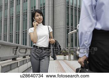 Stock Photo - a professional 
woman converses 
on the mobile 
phone as she moves. 
fotosearch - search 
stock photos, 
pictures, images, 
and photo clipart