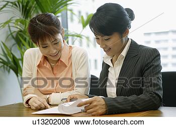 Stock Photo - two woman express 
happiness as they 
look over the 
sheet of the file. 
fotosearch - search 
stock photos, 
pictures, images, 
and photo clipart