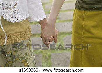 Picture - front view of 
two women holding 
each others hand. 
fotosearch - search 
stock photos, 
pictures, images, 
and photo clipart