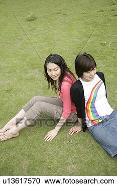 Stock Photography - two young women 
rest on each others 
back as they sit 
on the grassland. 
fotosearch - search 
stock photos, 
pictures, images, 
and photo clipart