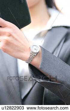 Stock Photo - a young businesswoman 
checking schedule, 
close-up. fotosearch 
- search stock 
photos, pictures, 
images, and photo 
clipart