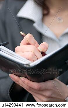 Stock Photography - a young woman 
checking schedule, 
close-up. fotosearch 
- search stock 
photos, pictures, 
images, and photo 
clipart