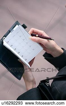 Stock Photo - a young woman 
checking schedule, 
close-up. fotosearch 
- search stock 
photos, pictures, 
images, and photo 
clipart