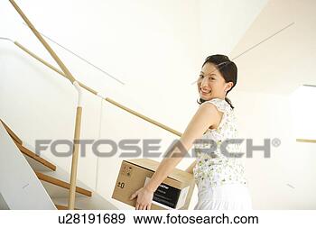 Stock Photograph - young woman carrying 
box. fotosearch 
- search stock 
photos, pictures, 
images, and photo 
clipart