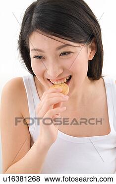 Stock Photo - young woman eating 
cookie. fotosearch 
- search stock 
photos, pictures, 
images, and photo 
clipart