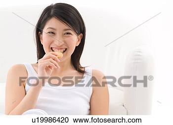 Stock Photography - young woman eating 
cookie. fotosearch 
- search stock 
photos, pictures, 
images, and photo 
clipart