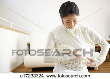 Stock Photo - young woman getting 
dressed. fotosearch 
- search stock 
photos, pictures, 
images, and photo 
clipart