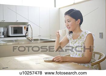 Stock Photo - young woman having 
coffee. fotosearch 
- search stock 
photos, pictures, 
images, and photo 
clipart