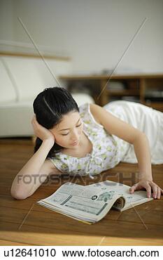 Stock Photography - young woman lying 
on floor and reading 
magazine. fotosearch 
- search stock 
photos, pictures, 
images, and photo 
clipart