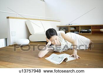 Stock Photo - young woman lying 
on floor and reading 
magazine. fotosearch 
- search stock 
photos, pictures, 
images, and photo 
clipart